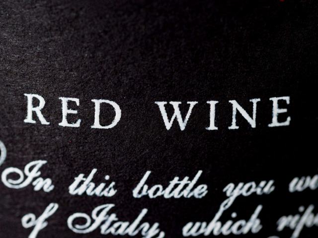 Déchiffrer l'étiquette d'une bouteille de vin suisse Gros plan sur l'étiquette noire d'une bouteille de vin rouge, lettres blanches