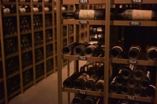 Casiers de cave en bois remplis de vieilles bouteilles classées par année
