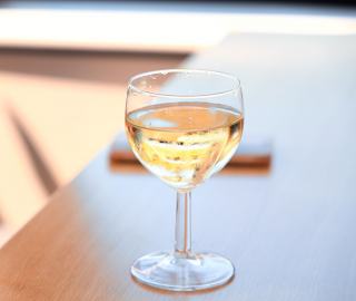 Verre de vin blanc frais posé sur une table en bois