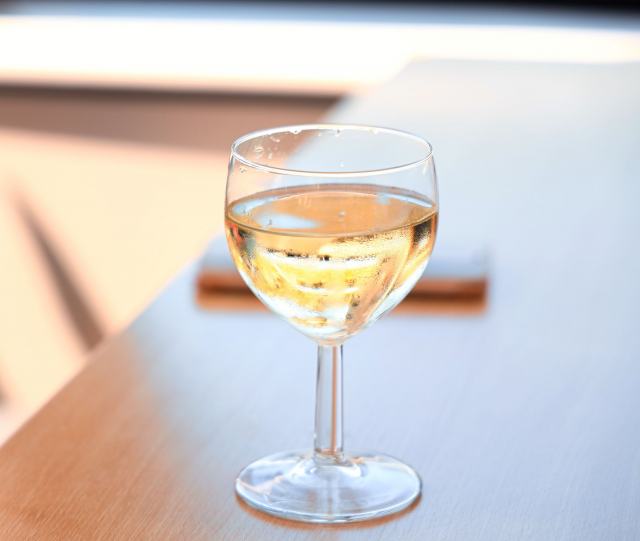 La petite arvine, grand blanc autochtone du Valais Verre de vin blanc frais posé sur une table en bois